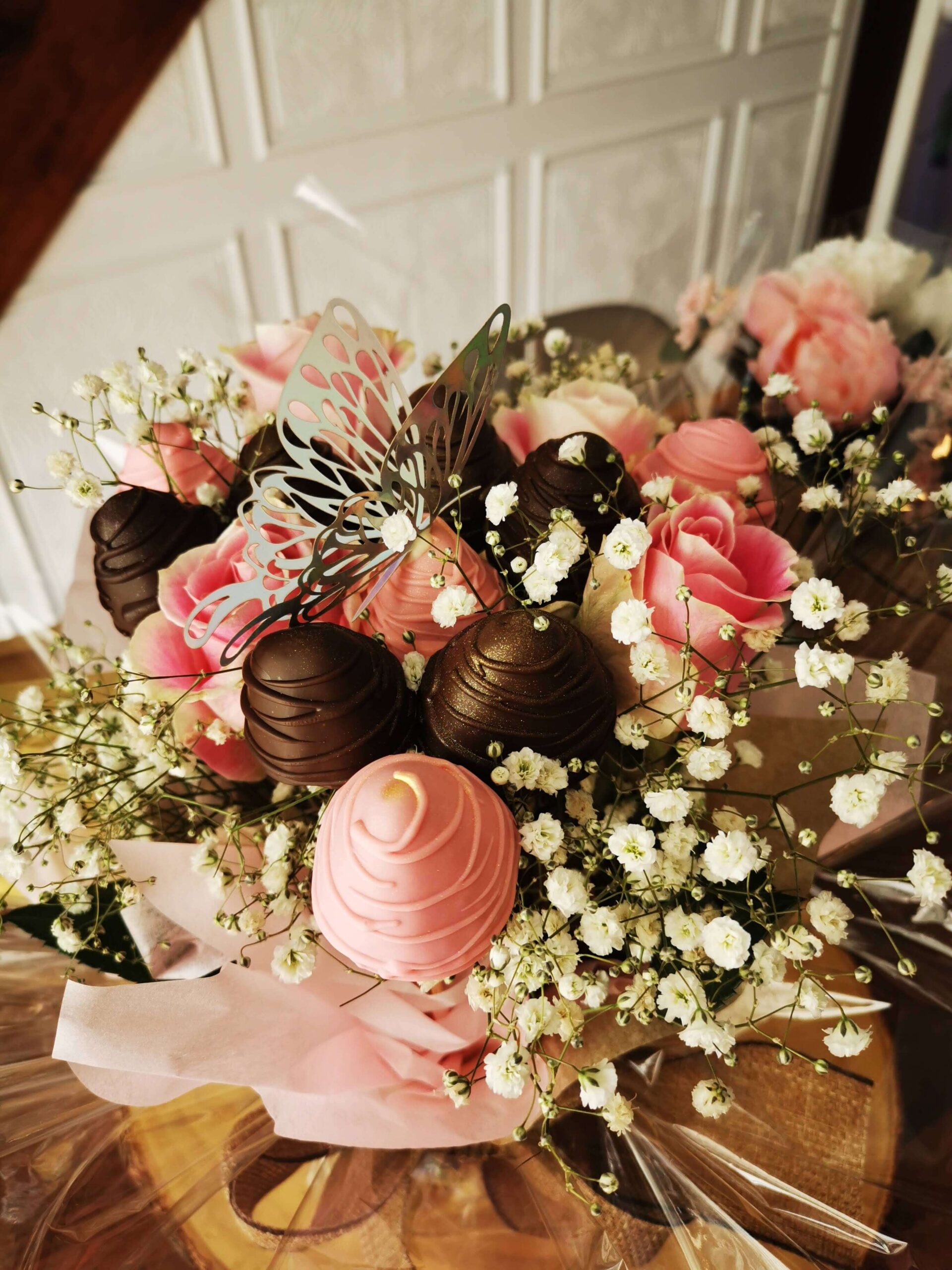 Bouquet de fraises de chocolat noir et Ruby (rose) décoré avec un papillon et petites fleurs blanches